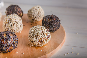 vegetarian food, energy balls of walnuts, dates, prunes, cranberries, honey with sesame