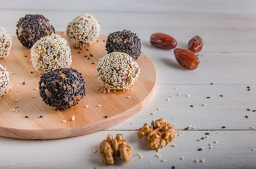 vegetarian food, energy balls of walnuts, dates, prunes, cranberries, honey with sesame