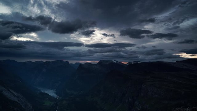 Clouds moving over mountains landscape. Evening view on green valley and fjord Geirangerfjord from Dalsnibba viewing point, Norway Scandinavia. Time lapse
