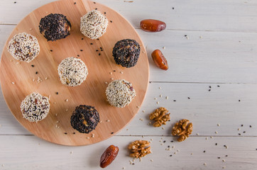 vegetarian food, energy balls of walnuts, dates, prunes, cranberries, honey with sesame