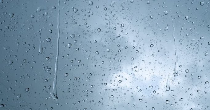 Rain drop on the car glass background.Road view through car window with rain drops, Driving in rain. Abstract traffic in raining day. View from car seat. Concept of: Drive, Fast, Alone, Car, Close up.