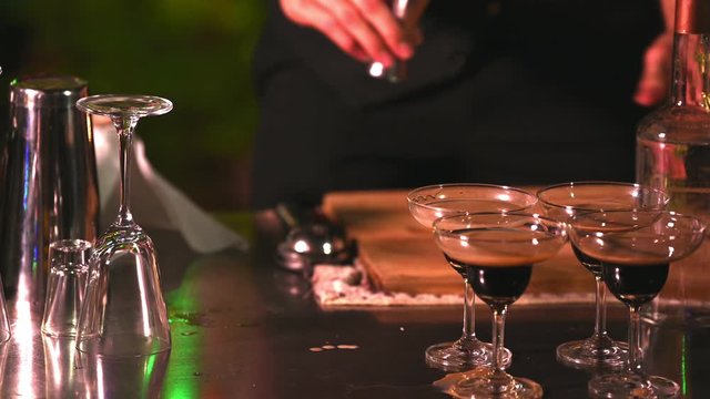 Close up attractive handsome Asian male bartender hand in black formal suit and red necktie mix and make cocktail as entertainer in part time job Happy birthday event. Occupation and people lifestyle.