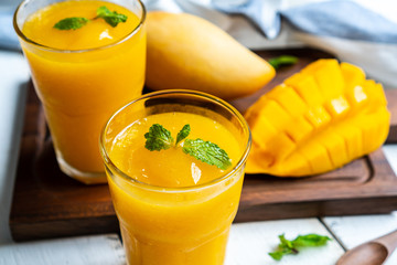 Refreshing and healthy mango smoothie in a glass with mango