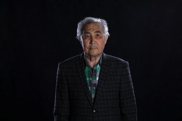portrait of a 90 year old man on a black background