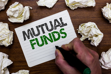 Conceptual hand writing showing Mutual Funds. Business photo showcasing An investment program funded by shareholders Individual Stocks Man holding marker notebook page crumpled papers mistakes