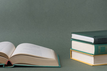 Open book, old textbooks, on paper green background.