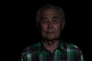 portrait of a 90 year old man on a black background