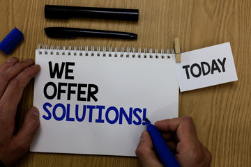 Word writing text We Offer Solutions. Business concept for Offering help assistance Experts advice strategies ideas Hand hold pen notepad with words paperclip grip note paper woody base black pen