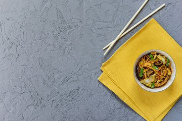 Yakisoba noodles in a bowl on the table. Asian cuisine, horizontal orientation, flat lay.