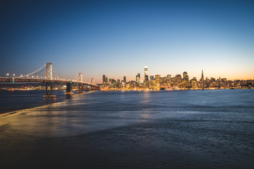 Fototapeta premium Panoramic beautiful scenic view of the Oakland Bay Bridge and the San Francisco city in the evening, California