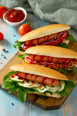 Traditional american fast food. Barbecue grilled Hot dog with fresh vegetables on wooden table.