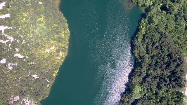 Aerial view of Aliakmonas river in valley and country road on the side, Veria Greece,  moving up and forward by drone