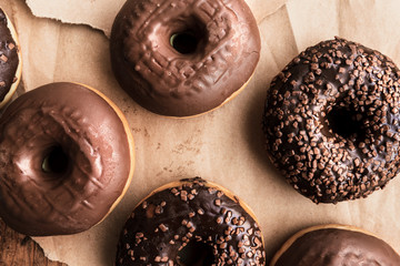 Tasty chocolate doughnuts with cream and crumbs