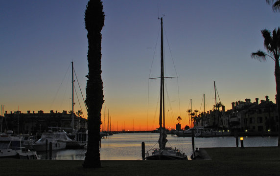 Amanecer en el puerto, barcos y sol se funden en el mismo entorno