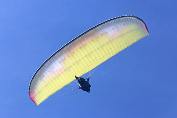 Tandem Paraglider flying yellow wing