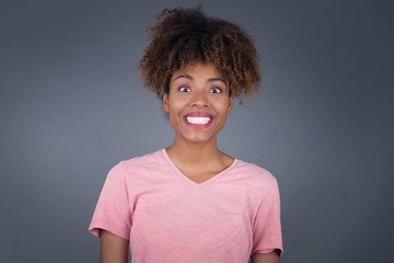 Young beautiful girl with an afro hairstyle having broad white smile being excited to meet Friends and go out to have a good day.