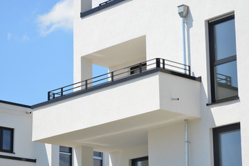 Moderne Betonbalkone und Attika-Schutzbleche an Neubau-Hausfront
