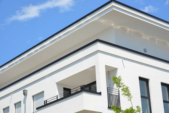 Moderne Betonbalkone und Attika-Schutzbleche an Neubau-Hausfront