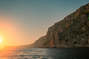 Sunset and Steep Cliffy Rocky Sea Shore. Sea and Rocks.