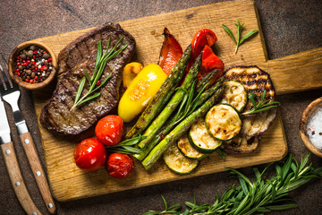 Beef steak grilled with vegetables on cutting board