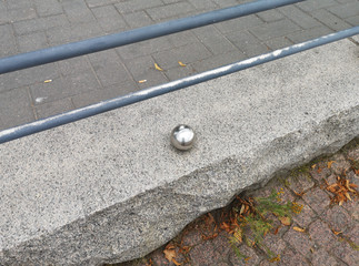 A small polished steel ball on the parapet of the seaport in Helsinki