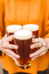 Woman holding three glasses of beer