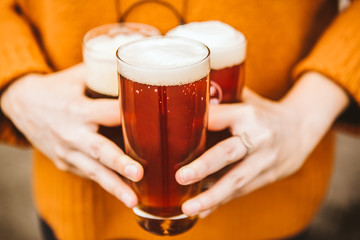 Woman holding three glasses of beer