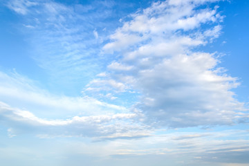 White light fluffy stratus and cirrus clouds high in the blue summer sky. Different cloud types and atmospheric phenomena. - obrazy, fototapety, plakaty