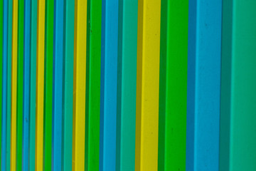 Obraz premium Abstract perspective pattern of green & yellow & blue metal vertical bars
