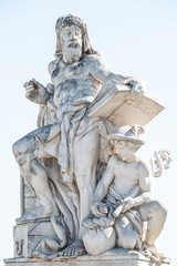 Sculpture of scientist with a book and his scholar on Zoll Bridge in Magdeburg downtown at direct light background, Germany, details, closeup