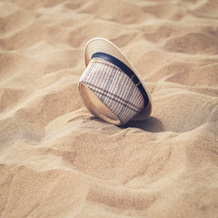 Fototapeta na wymiar Lost in desert. The sun hat on the sand.
