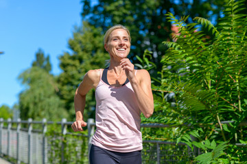 Happy healthy woman jogging outdoors