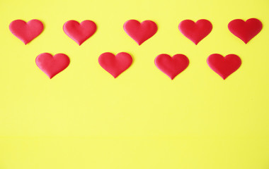 Red hearts of romantic love on a yellow background with copy space for text and image. Flat lay....