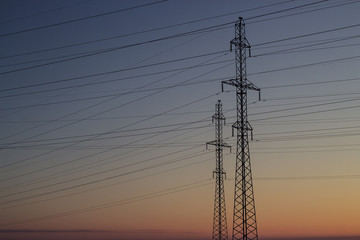 Power lines on a background of a winter sunset. Winter landscape. Copy space.