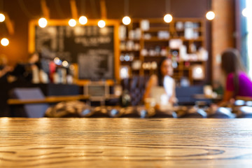 Wooden top table with blurred of coffee shop background. Mockup wooden desk for display or montage your products. Blur in coffee shop or cafe, restaurant background.