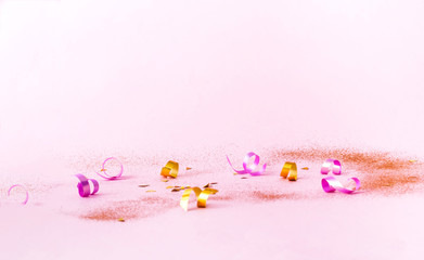 Confetti on pink background with golden sparkles. Concept for festive background or for project