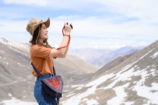 Portrait of young Asian woman talking photos on snow mountain, outdoors and traveller concept
