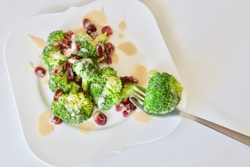 Tasty vegan broccoli salad on the white plate.