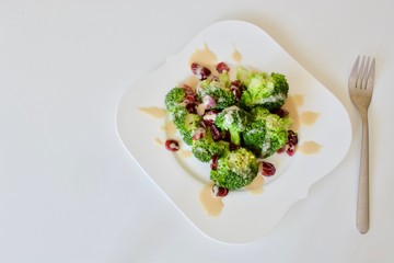 Tasty vegan broccoli salad on the white plate.