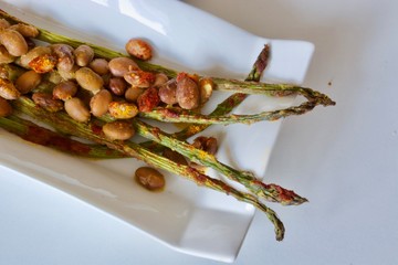 Tasty vegan asparagus with kidney beans on the white plate.