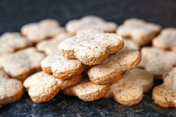 Nuts stack cookies. Many walnut cookies lay on a dark marble table.