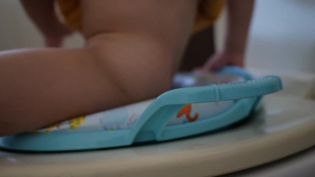 cute child sitting on flush toilet