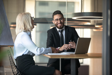 Mature businesswoman and young businessman having fun at work