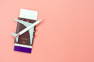 Table top view accessory of accessory travel in holiday background concept.Flat lay of airplane with passport and boarding pass ticket on modern rustic pink paper at home studio office desk.copy space