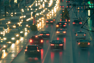 Defocused image of hard night for drivers. Big traffic in the city. In the summer urban highway filled cars. To be late. Long exposure. For greeting card design, postcard template, guide, poster.