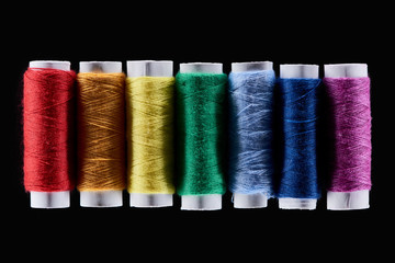 top view of bright and colorful threads isolated on black