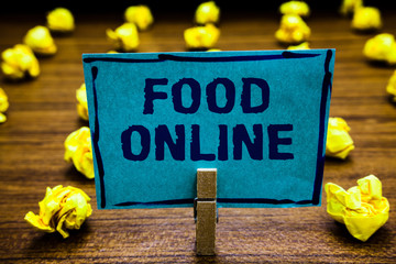 Naklejka premium Word writing text Food Online. Business concept for asking for something to eat using phone app or website Clothespin holding blue paper note crumpled papers several tries mistakes