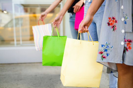 Closeup of young happy women with colorful shopping bags