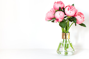 Peony flower bouquet in a vase on the white background close up frame. Copy space