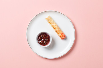 Wafer rolls with a sweet sauce. On a multicolored background. Minimalism